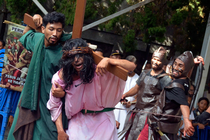 Umat Katolik memvisualisasikan penyaliban Yesus saat prosesi Tablo Kisah Sengsara Yesus Kristus di Gereja Santo Fransiskus Xaverius, Kuta, Bali.