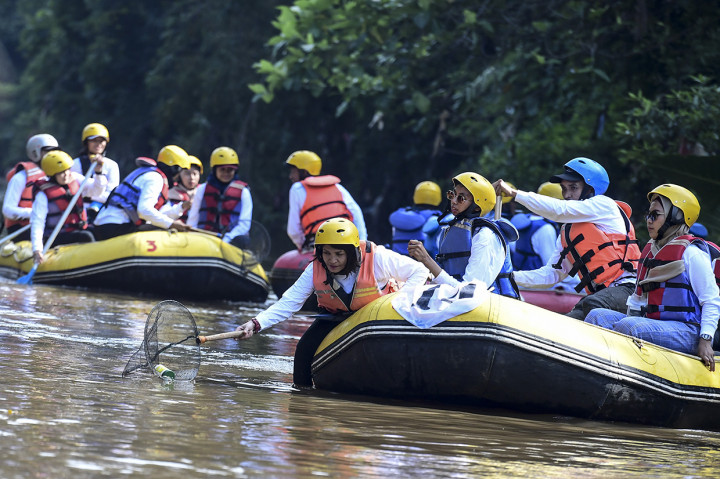 Pekerja milenial perempuan PT Askrindo (Persero) mengambil sampah di aliran sungai saat operasi bersih Sungai Ciliwung di Jakarta. Millenials Askrindo bersama Yayasan Lintas Sungai Abadi (Yalisa) membersihkan Sungai Ciliwung untuk merayakan HUT ke-48 Askrindo dan Hari Kartini. Antara Foto/Hafidz Mubarak A
