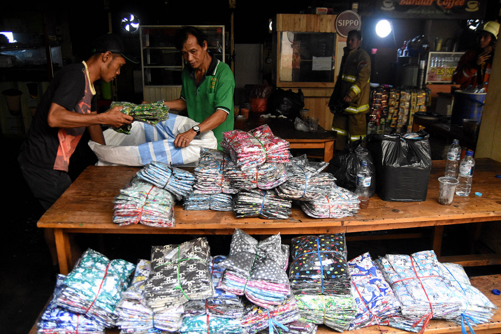 Pedagang mengevakuasi barang dagangan usai terjadinya kebakaran di Gudang baju blok C Pasar Tanah Abang, Jakarta.