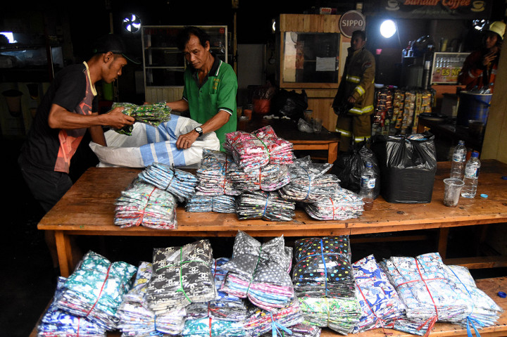 Pedagang mengevakuasi barang dagangan usai terjadinya kebakaran di Gudang baju blok C Pasar Tanah Abang, Jakarta.