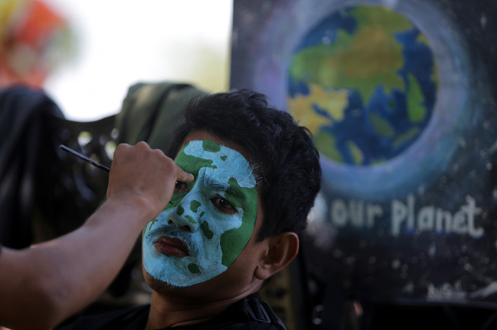 Aktivis merias wajah dengan gambar bumi saat mengikuti aksi damai peringatan Hari Bumi di depan Masjid Raya Baiturrahman, Banda Aceh, Aceh. Antara Foto/Irwansyah Putra