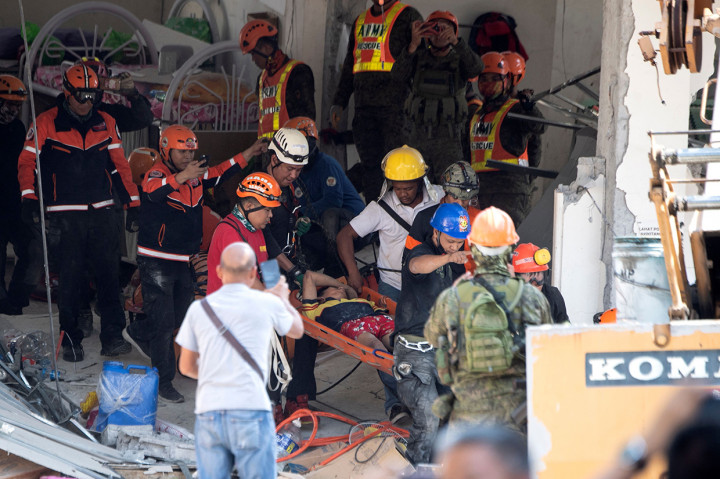 yang terperangkap setelah sebuah bangunan berlantai empat runtuh, menghancurkan supermarket di lantai dasar.