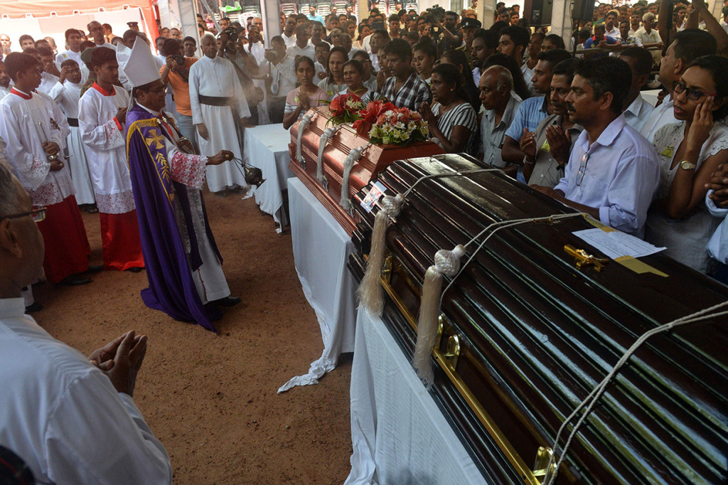 Seorang pendeta Sri Lanka memberkati peti mati korban ledakan bom selama kebaktian pemakaman di Gereja St Sebastian di Negombo. Afp Photo/Ishara S. Kodikara