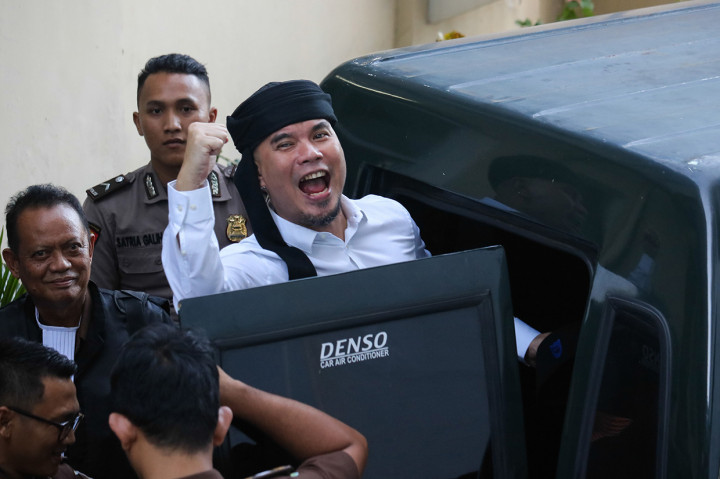 Terdakwa kasus dugaan pencemaran nama baik Ahmad Dhani Prasetyo (kanan) masuk ke mobil tahanan usai mengikuti sidang tuntutan di Pengadilan Negeri Surabaya, Jawa Timur.