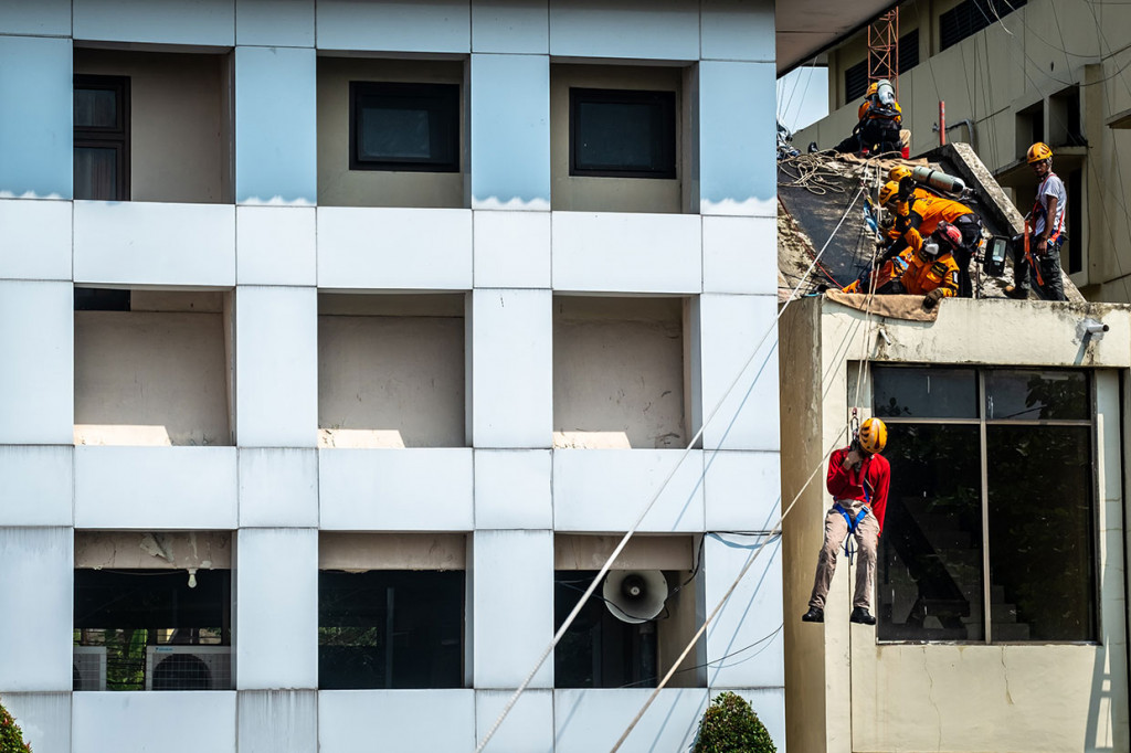 Tim relawan gabungan menyelamatkan korban dari dalam gedung yang terbakar dengan teknik 'vertical rescue' saat simulasi bencana di Ungaran, Kabupaten Semarang, Jawa Tengah. Antara Foto/Aji Styawan