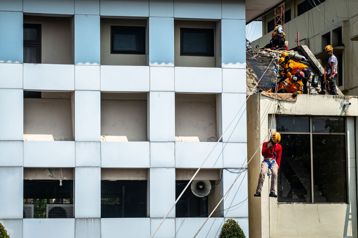 Tim relawan gabungan menyelamatkan korban dari dalam gedung yang terbakar dengan teknik 'vertical rescue' saat simulasi bencana di Ungaran, Kabupaten Semarang, Jawa Tengah. Antara Foto/Aji Styawan