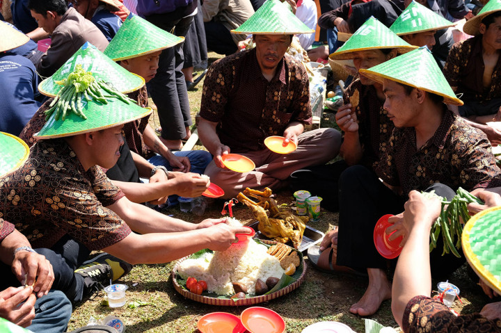 Usai berdoa mereka makan bersama dengan menu tumpeng dan ingkung ayam. Sementara dua gunungan besar yang terbuat dari hasil bumi termasuk tembakau menjadi rebutan para pengunjung.
