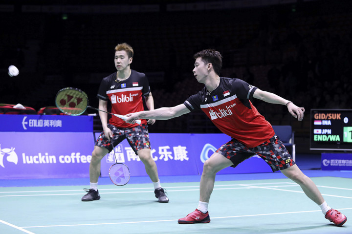 Pebulu tangkis ganda putra Indonesia Kevin Sanjaya Sukamuljo (kanan) dan Marcus Fernaldi Gideon berusaha mengembalikan kok ke arah ganda putra Jepang Hiroyuki Endo dan Yuta Watanabe pada final Badminton Asia Championships 2019 di Wuhan Sport Center, Tiongkok. 
