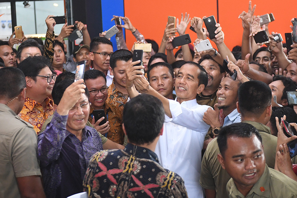 Presiden Joko Widodo berswafoto dengan para pekerja saat mengunjungi pabrik sepatu PT KMK Global Sports I. Jokowi mengelilingi pabrik dan menyapa para buruh sepatu.