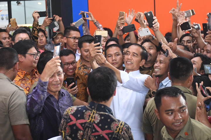 Presiden Joko Widodo berswafoto dengan para pekerja saat mengunjungi pabrik sepatu PT KMK Global Sports I. Jokowi mengelilingi pabrik dan menyapa para buruh sepatu.
