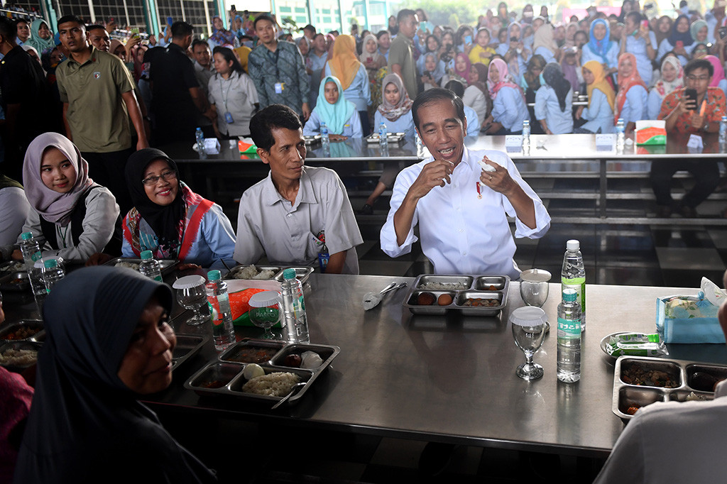 Jokowi menyantap makan siang bersama para buruh yang sedang beristirahat. Para menteri yang mendampingi Jokowi juga ikut makan bersama.