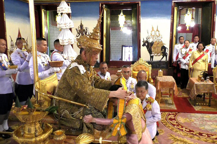 Vajiralongkorn menyematkan selempang kepada Permaisuri Suthida - yang dinikahinya beberapa hari sebelum penobatan.
