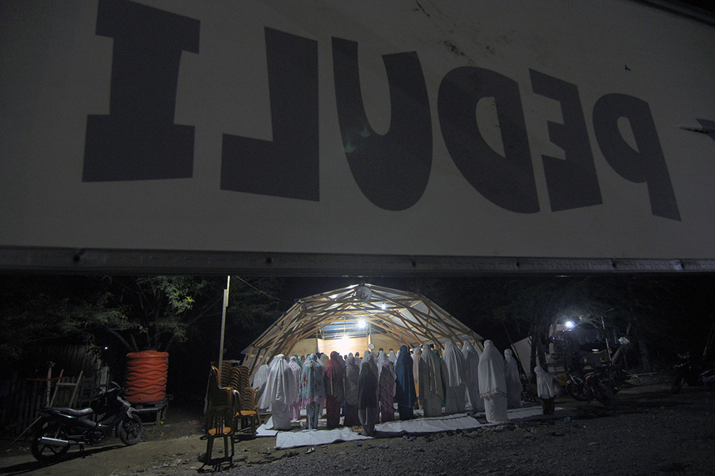 Sejumlah umat muslim pengungsi korban bencana gempa dan tsunami melaksanakan shalat Tarawih pertama dengan menggunakan tempat ibadah sementara di Palu, Sulawesi Tengah. Antara Foto/Mohamad Hamzah