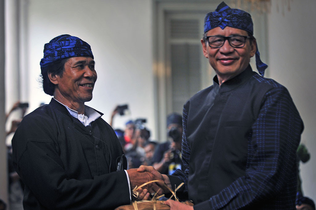 Jaro Saidi Putra (kiri) menyerahkan hasil bumi kepada Gubernur Banten Wahidin Halim (kanan) saat acara Seba Baduy di Pendopo Gubernur Banten, di Serang.