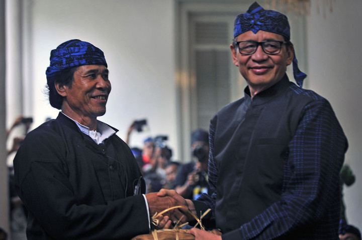 Jaro Saidi Putra (kiri) menyerahkan hasil bumi kepada Gubernur Banten Wahidin Halim (kanan) saat acara Seba Baduy di Pendopo Gubernur Banten, di Serang.