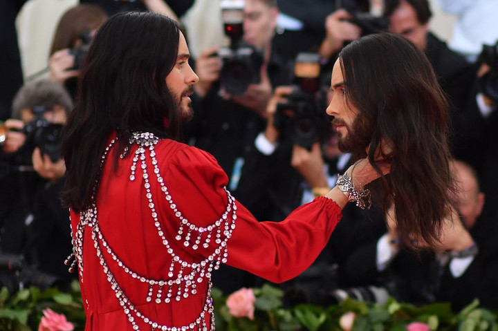Jared Leto tampil dengan jubah merah bertabur berlian dari rumah mode Gucci. Uniknya Leto bawa replika kepalanya sendiri.