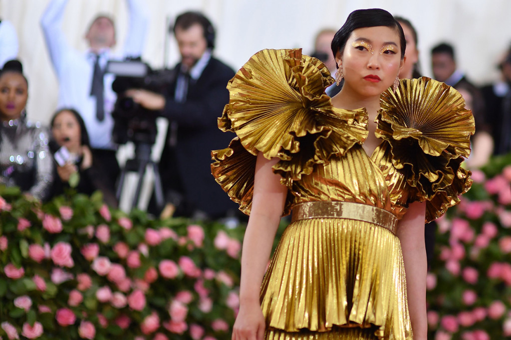 Dalam debutnya di Met Gala, Awkwafina tampil dengan busana rancangan Joseph Altuzarra. Bintang Crazy Rich Asian ini hadir mengenakan gaun berkilau emas yang dibuat berlapis dengan lengan bergaya ruffle.