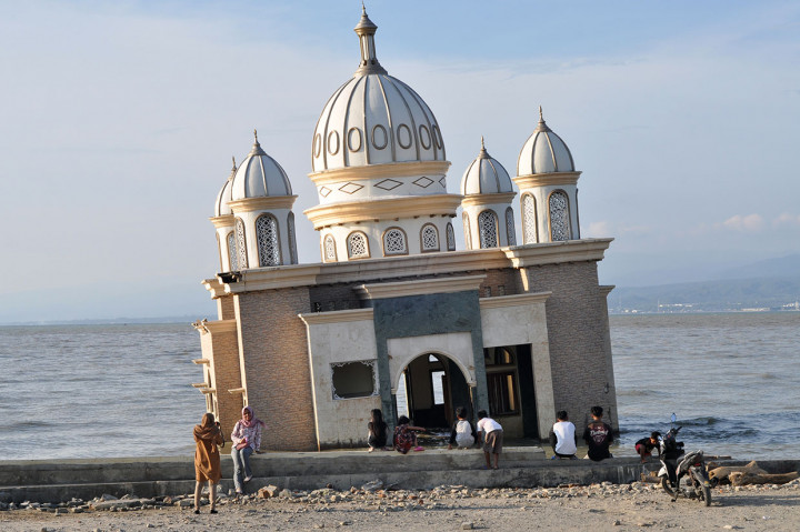 Warga menunggu waktu berbuka puasa (ngabuburit) bulan Ramadhan 1440 H di Masjid terapung yang rusak akibat gempa dan tsunami di Palu, Sulawesi Tengah. Antara Foto/Muhamad Hamzah