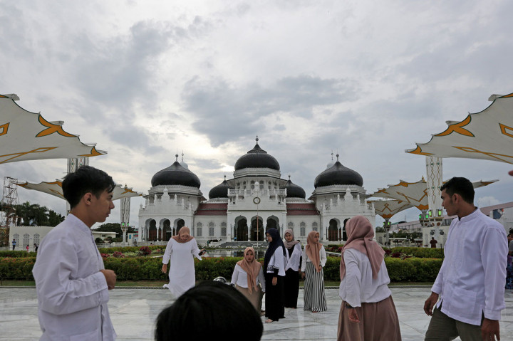 Warga menikmati panorama masjid Raya Baiturrahman sambil menunggu waktu untuk berbuka puasa (ngabuburit) di Banda Aceh, Aceh. Antara Foto/Irwansyah Putra