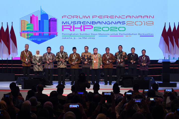 Presiden Joko WIdodo (tengah) didampingi Menteri Perencanaan Pembangunan Nasional/Kepala Bappenas Bambang Brodjonegoro (kelima kanan) berfoto dengan kepala daerah peraih penghargaan saat membuka acara Musyawarah Perencanaan Pembangunan Nasional (Musrenbangnas) 2019 di Jakarta.