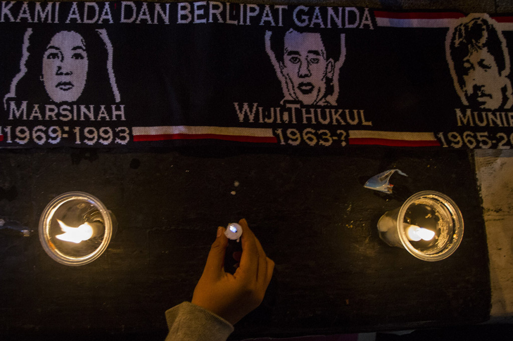 Warga menyalakan lilin di dekat syal bergambar Marsinah, Wiji Thukul dan Munir pada aksi mengenang 26 tahun kasus Marsinah di Taman Vanda, Bandung, Jawa Barat. Aksi tersebut merupakan peringatan 26 tahun kasus pembunuhan Marsinah yang belum tuntas hingga saat ini. Antara Foto/Novrian Arbi