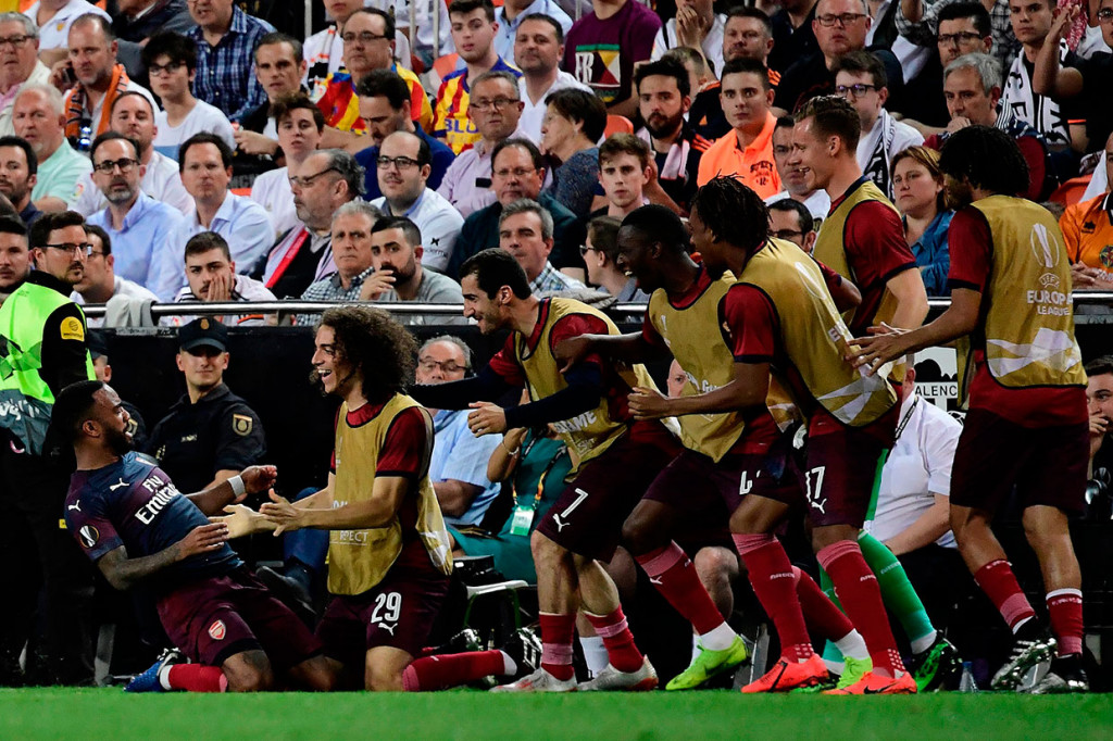 Lacazette melakukan selebrasi bersama rekan-rekan setimnya usai menaklukkan kiper Valencia Neto.