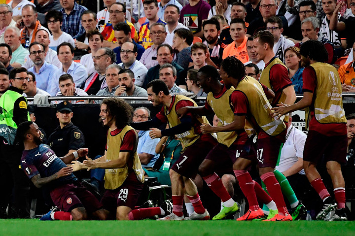 Lacazette melakukan selebrasi bersama rekan-rekan setimnya usai menaklukkan kiper Valencia Neto.