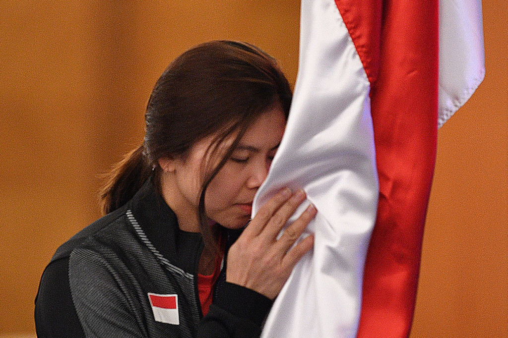 Pebulutangkis putri Indonesia Greysia Polii mencium bendera Merah Putih saat prosesi pelepasan Tim Piala Sudirman 2019.