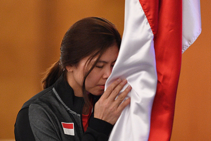 Pebulutangkis putri Indonesia Greysia Polii mencium bendera Merah Putih saat prosesi pelepasan Tim Piala Sudirman 2019.