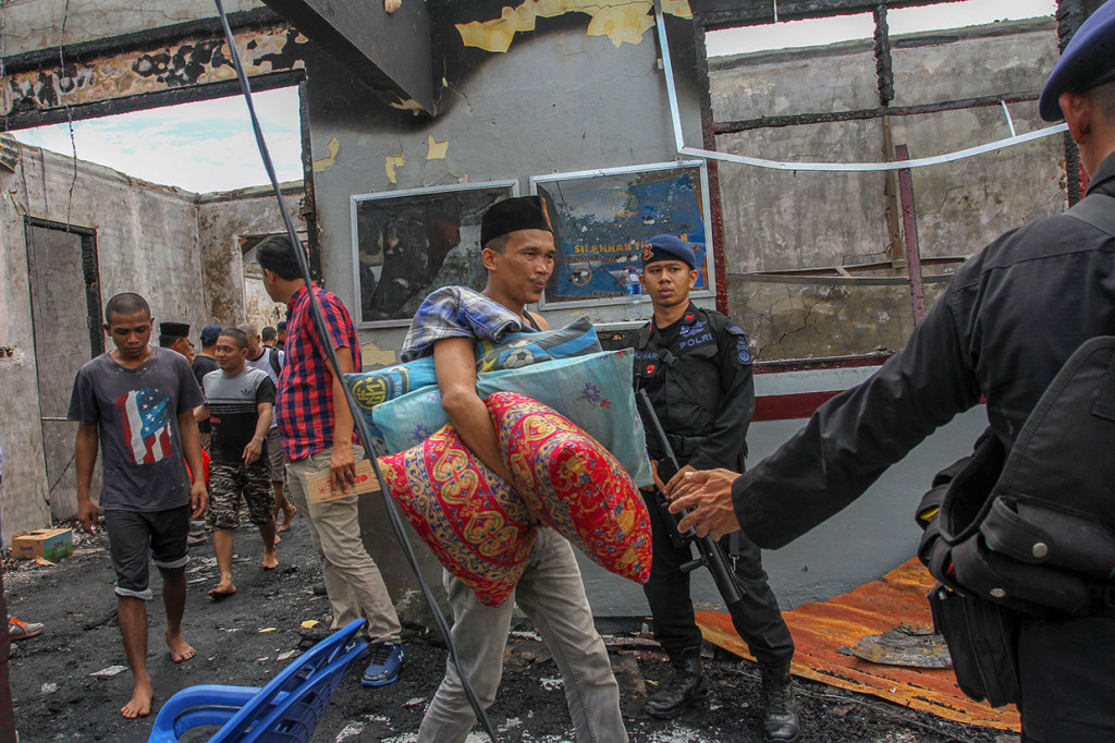 Sejumlah narapidana mengikuti proses pemindahan dengan pengawalan kepolisian pascakerusuhan yang terjadi di Rutan Kelas II B Siak Sri Indrapura, Kabupaten Siak, Riau, Sabtu, 11 Mei 2019.