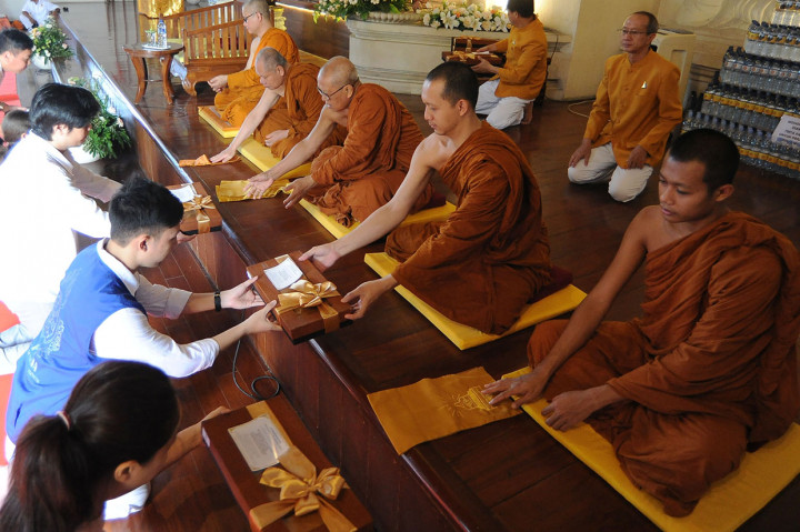 Umat Buddha memberikan persembahan berupa jubah kepada Bhikkhu saat upacara Pattidana di Vihara Buddha Sakyamuni, Denpasar, Bali.