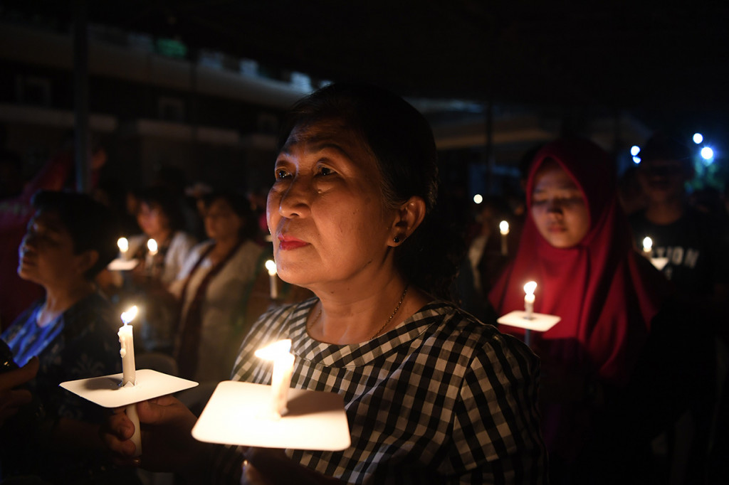 Sejumlah umat katolik dan umat lintas agama berdoa bersama saat peringatan setahun tragedi bom gereja Surabaya di Gereja Katolik Santa Maria Tak Bercela, Surabaya, Jawa Timur.