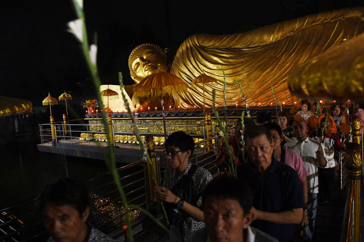 Umat Buddha mengelilingi patung Buddha Tidur saat perayaan Waisak 2563 BE di Maha Vihara Mojopahit Trowulan, Mojokerto, Jawa Timur.