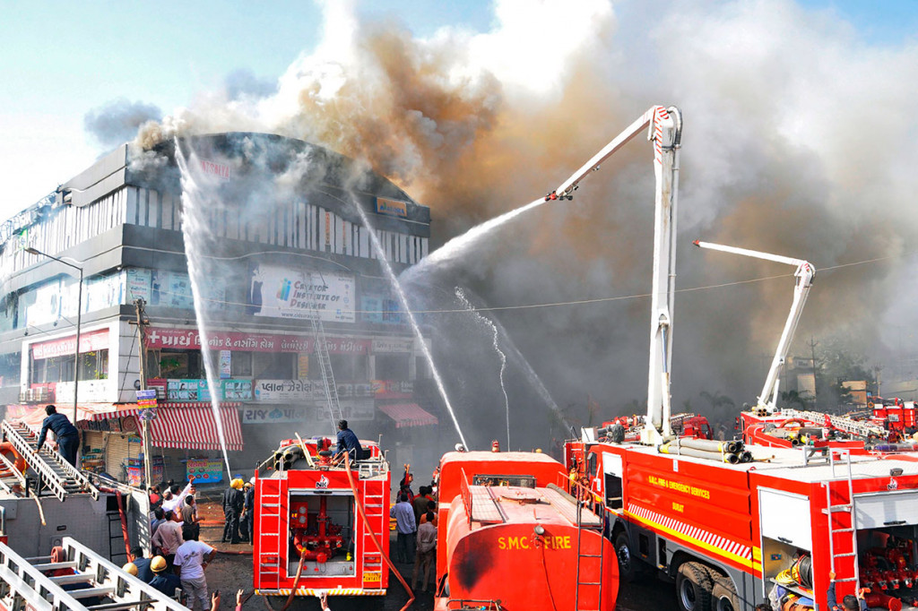 Petugas pemadam kebakaran India berusaha mengendalikan kebakaran besar yang melahap sebuah gedung bertingkat di Surat, sekitar 270 km dari Ahmedabad, Jumat, 24 Mei 2019.