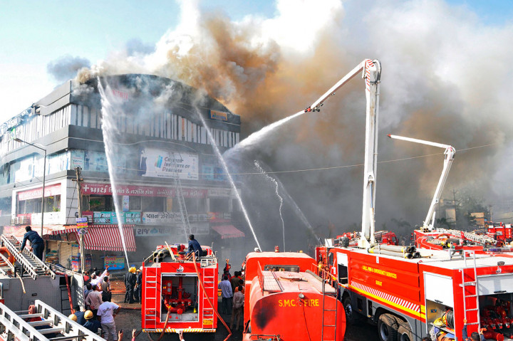 Petugas pemadam kebakaran India berusaha mengendalikan kebakaran besar yang melahap sebuah gedung bertingkat di Surat, sekitar 270 km dari Ahmedabad, Jumat, 24 Mei 2019.
