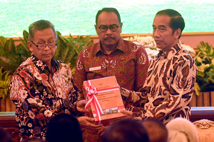 Presiden Joko Widodo (kanan) menerima Laporan Hasil Pemeriksaan atas Laporan Keuangan Pemerintah Pusat (LHP LKPP) tahun 2018 dan Ikhtisar Hasil Pemerikaan Semester (IHPS) II tahun 2018 dari Ketua BPK Moermahadi Soerja Djanegara (kiri) dan Wakil Ketua BPK Bahrullah Akbar (tengah) di Istana Negara, Jakarta.