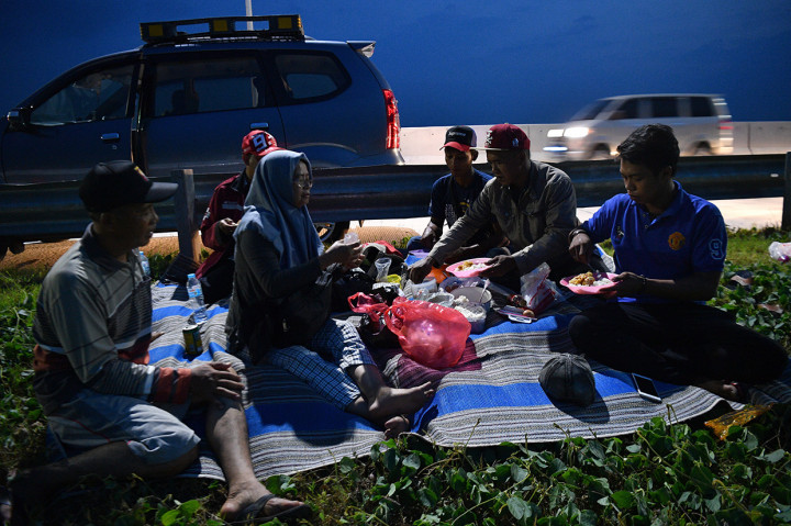 Pemudik menyantap makanan untuk berbuka puasa di pinggir ruas jalan tol Pejagan-Pemalang, Tegal, Jawa Tengah. Antara Foto/Sigid Kurniawan