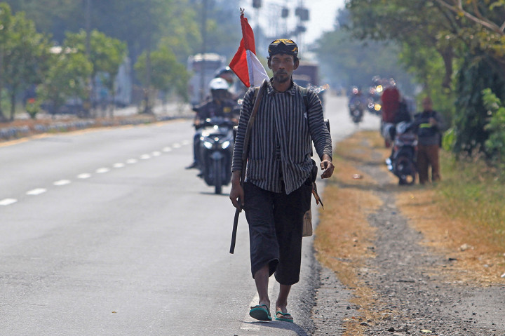 Doni (48) berjalan kaki melintasi jalur Pantura Arjawinangun, Cirebon, Jawa Barat.