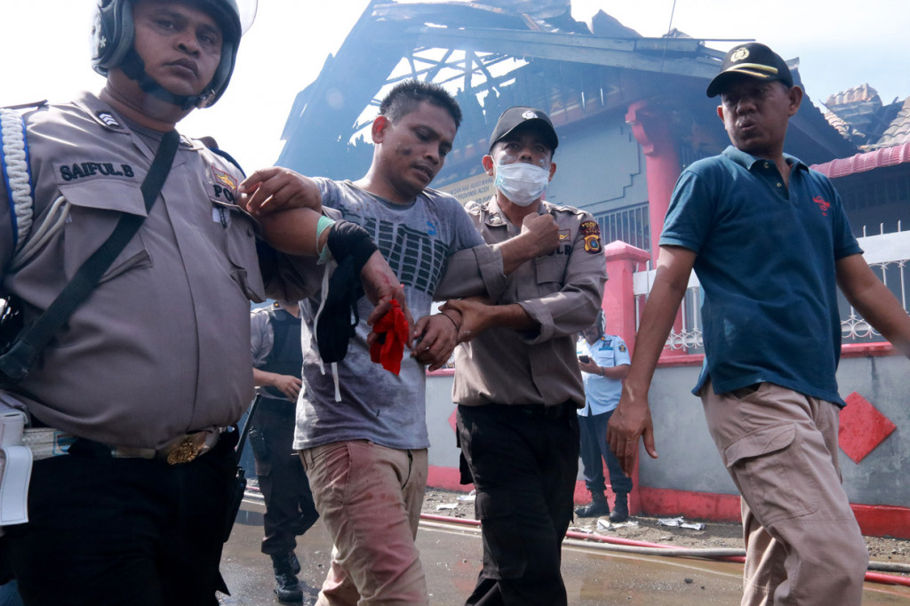 Para napi membakar ruang kerja kepala pengamanan Rutan. Api seketika membumbung tinggi.
