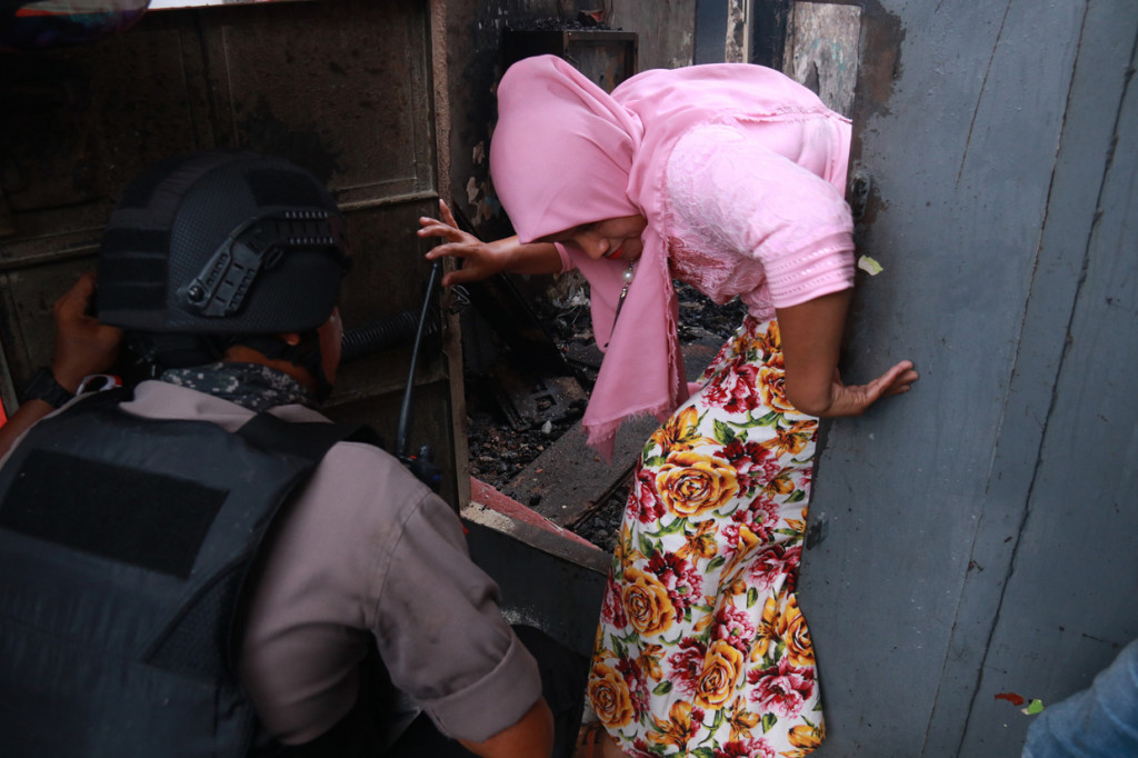 Anggota Polisi mengevakuasi seorang wanita usai terjadinya kerusuhan di Rumah Tahanan (Rutan) Klas II B Sigli, Aceh.