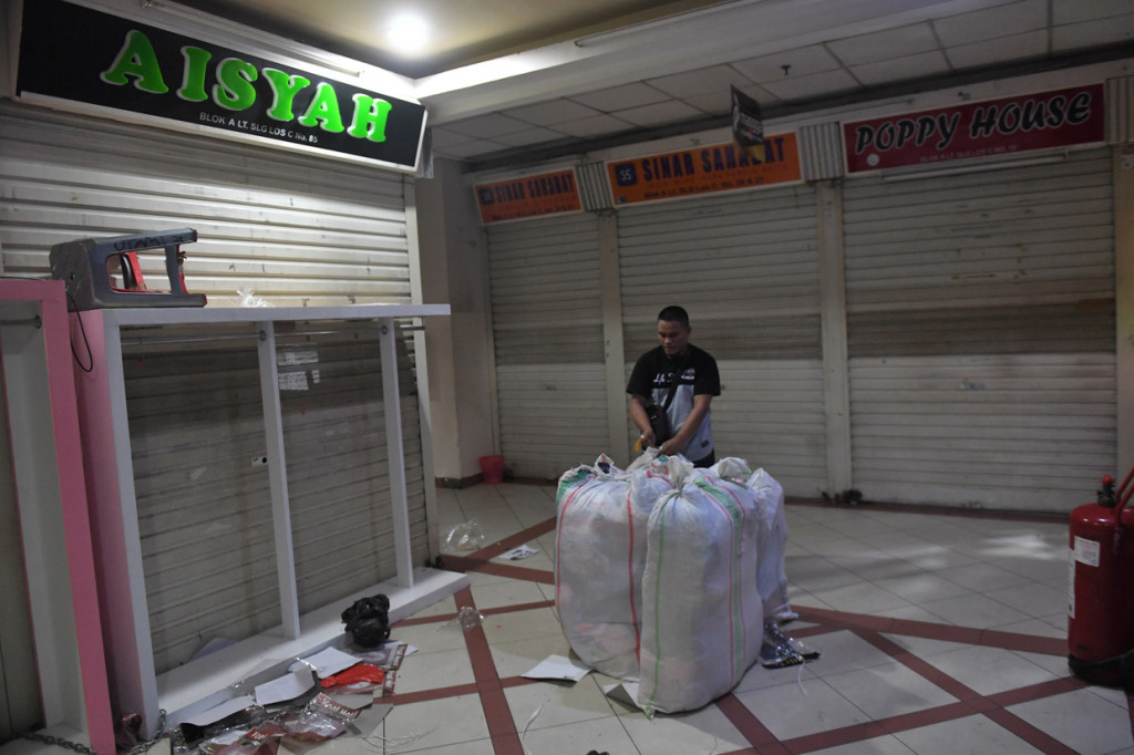 Pedagang merapikan dagangan sebelum menutup tokonya di Pasar Tanah Abang, Jakarta.
