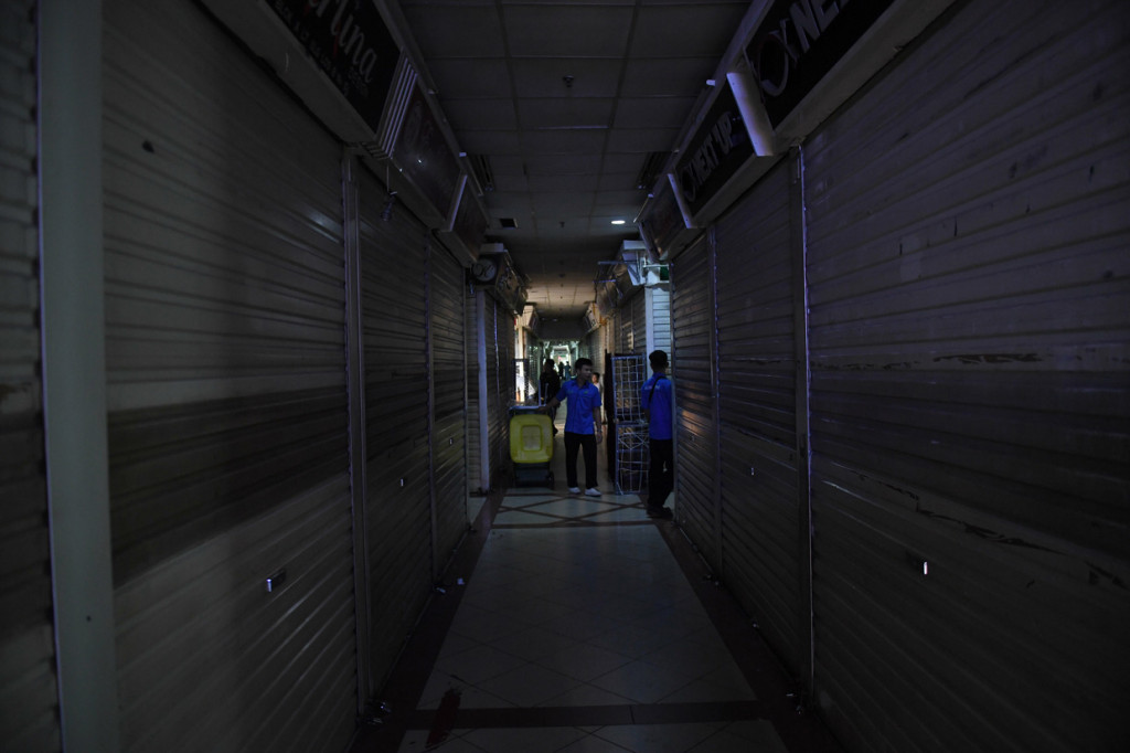 Petugas kebersihan membawa keranjang sampah usai sejumlah pedagang menutup tokonya di Pasar Tanah Abang, Jakarta.