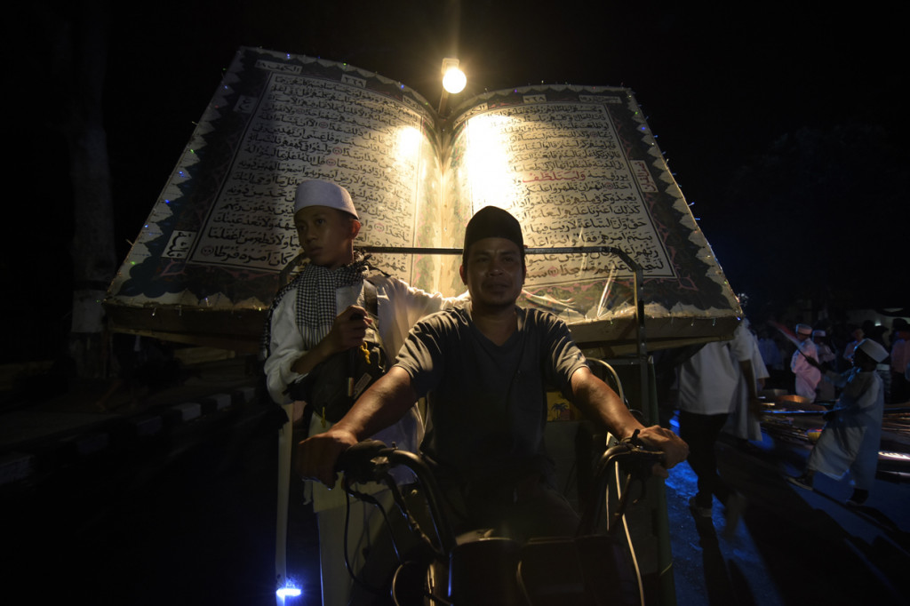 Umat muslim membawa replika Alquran saat melakukan takbiran keliling melalui jalan-jalan protokol di Mataram, NTB. Antara Foto/Ahmad Subaidi