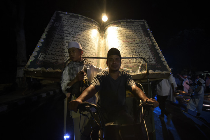 Umat muslim membawa replika Alquran saat melakukan takbiran keliling melalui jalan-jalan protokol di Mataram, NTB. Antara Foto/Ahmad Subaidi