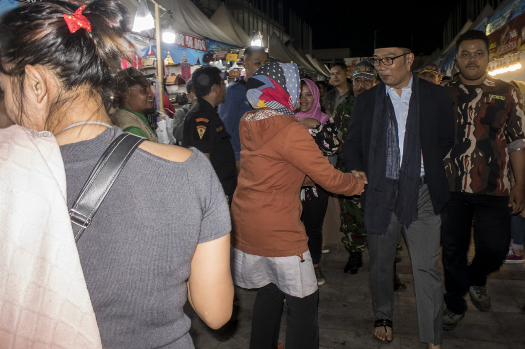 Gubernur Provinsi Jawa Barat bersalaman dengan warga saat meninjau suasana malam takbiran idulfitri 1440 hijriah di kawasan Alun alun Masjid Raya Bandung, Jawa Barat. Tradisi malam takbiran dilakukan umat muslim indonesia pada umumnya dalam menyambut hari raya idul Fitri sebagai makna kemenangan usai berpuasa sebulan penuh pada bulan ramadhan. Antara Foto/Novrian Arbi
