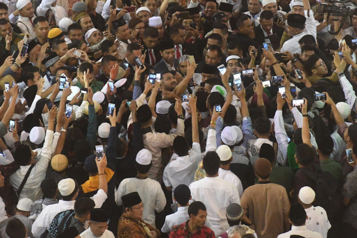 Presiden Joko Widodo (tengah) menerima ajakan swafoto warga usai melakukan Shalat Id di Masjid Istiqlal, Jakarta.