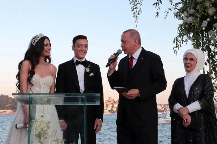 Presiden Turki Recep Tayyip Erdogan menyerahkan buku nikah kepada Ozil dan Amine saat seremoni pengucapan janji pernikahan. Afp Photo/Turkish Presidential Press Servi