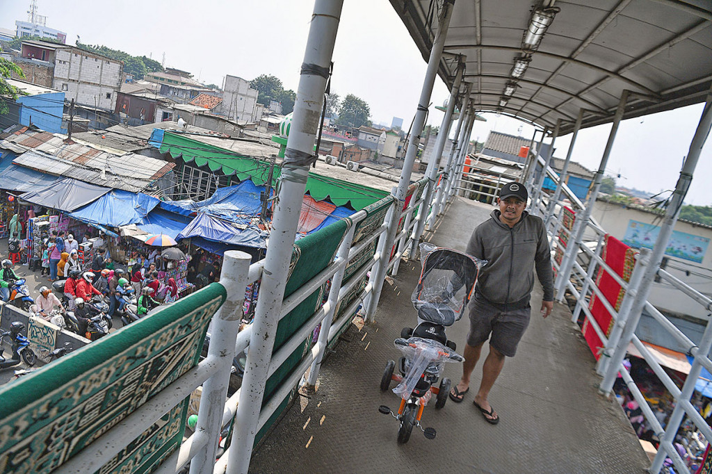 Warga membawa sepeda anak yang dibeli di Pasar Gembrong, Jakarta Timur.
