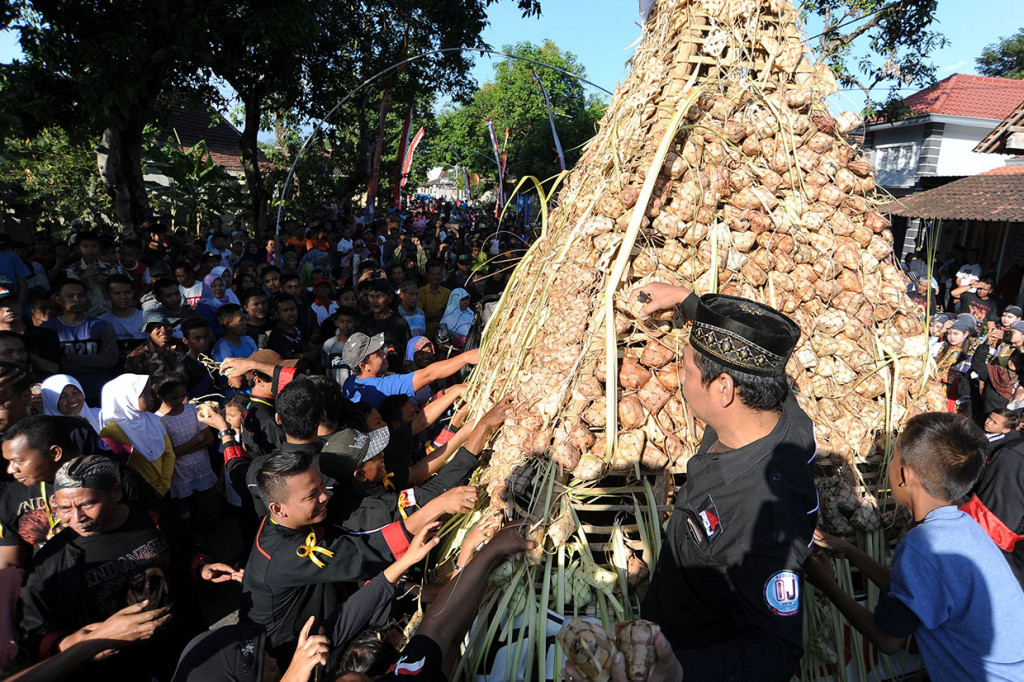 Sejumlah warga berebut ketupat saat Festival 1.001 Ketupat di Desa Kalimalang, Ponorogo, Jawa Timur.