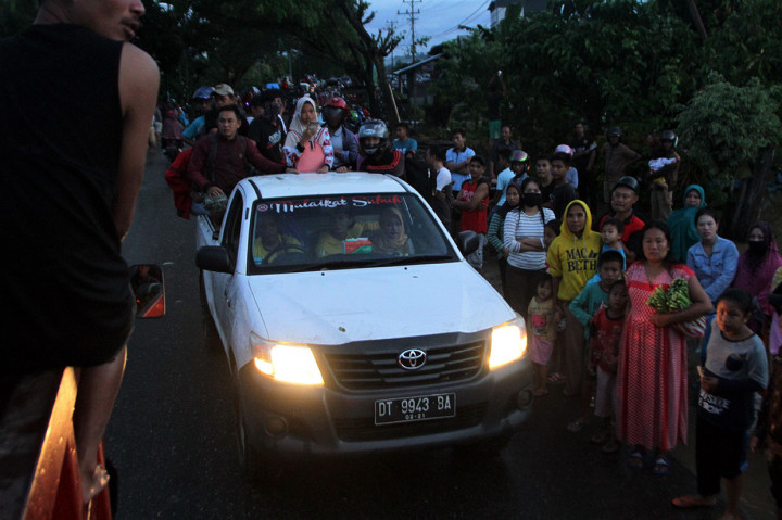 Sejumlah warga korban banjir bandang berada di atas mobil bak terbuka menuju lokasi pengungsian di Desa Uepai, Konawe, Sulawesi Tenggara, Senin, 10 Juni 2019 petang.